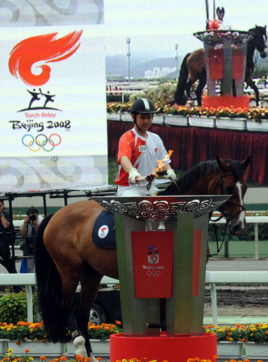火炬手、香港马术运动员郑文杰在点圣火盆