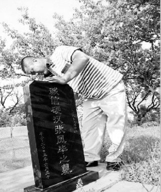 张福正一遍又一遍地擦拭父亲的墓碑。